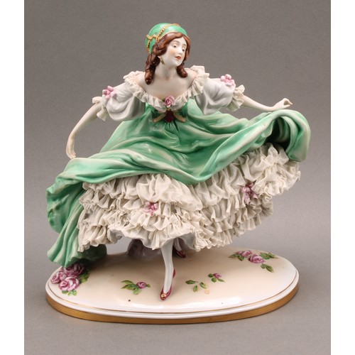 231 - A German Scheibe-Alsbach porcelain figure of a female dancer, wearing a green dress with lace porcel... 