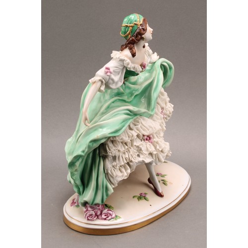 231 - A German Scheibe-Alsbach porcelain figure of a female dancer, wearing a green dress with lace porcel... 