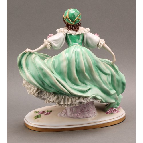 231 - A German Scheibe-Alsbach porcelain figure of a female dancer, wearing a green dress with lace porcel... 