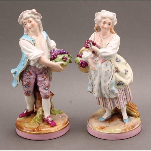 254 - A pair of German porcelain figures, as a grape farmer and his female companion, each carrying a bask... 