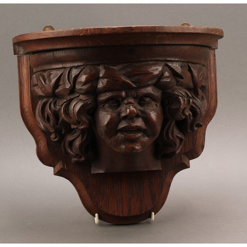 1969 - A 19th century oak wall bracket, boldly carved in the manner of a Medieval corbel with the head of a... 