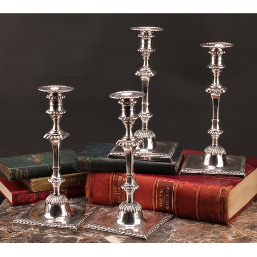 907 - A set of four early George III Scottish silver cast table candlesticks, campana sconces with detacha... 