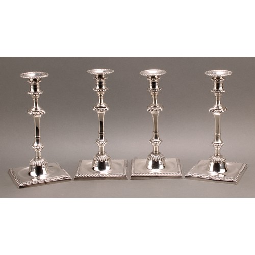 907 - A set of four early George III Scottish silver cast table candlesticks, campana sconces with detacha... 