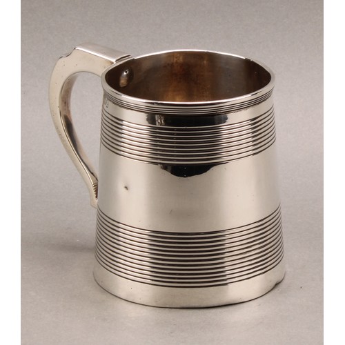 788 - A George III silver spreading cylindrical mug, moulded rim above two broad reeded bands, scroll hand... 