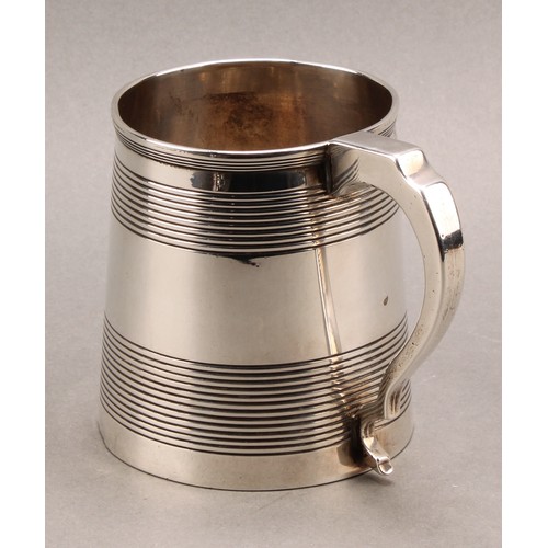 788 - A George III silver spreading cylindrical mug, moulded rim above two broad reeded bands, scroll hand... 