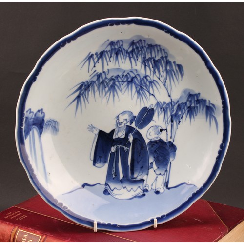 1288 - A 19th century Chinese dish, painted in tones of underglaze blue, depicting a scholar attended by a ... 