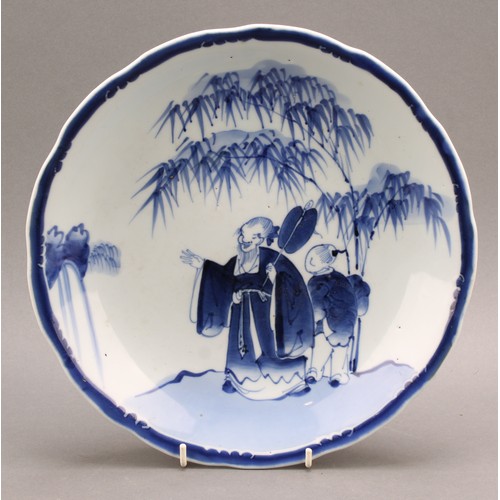 1288 - A 19th century Chinese dish, painted in tones of underglaze blue, depicting a scholar attended by a ... 