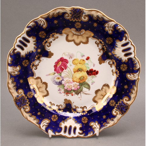 97 - A pair of English porcelain shaped circular plates, the field painted with colourful flowers, cobalt... 