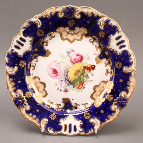 97 - A pair of English porcelain shaped circular plates, the field painted with colourful flowers, cobalt... 