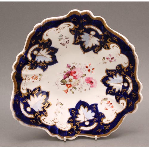 97 - A pair of English porcelain shaped circular plates, the field painted with colourful flowers, cobalt... 