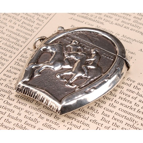 1014 - An early 20th century silver novelty vesta case, embossed with a horse racing scene within a horsesh... 