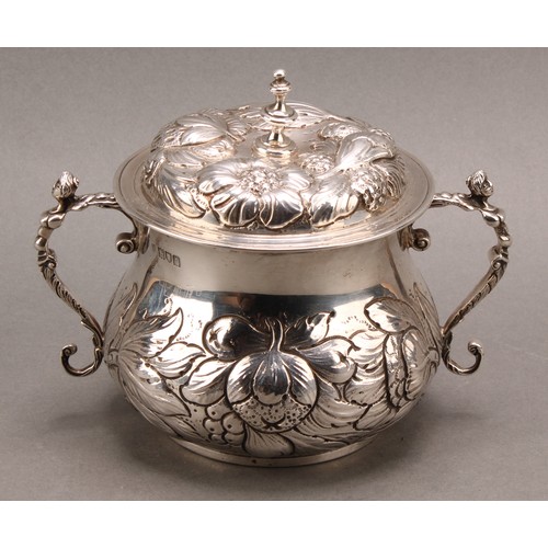 973 - A William & Mary style silver porringer and cover, chased with fruiting foliage, scroll handles cres... 