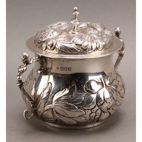 973 - A William & Mary style silver porringer and cover, chased with fruiting foliage, scroll handles cres... 