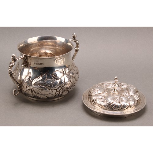 973 - A William & Mary style silver porringer and cover, chased with fruiting foliage, scroll handles cres... 