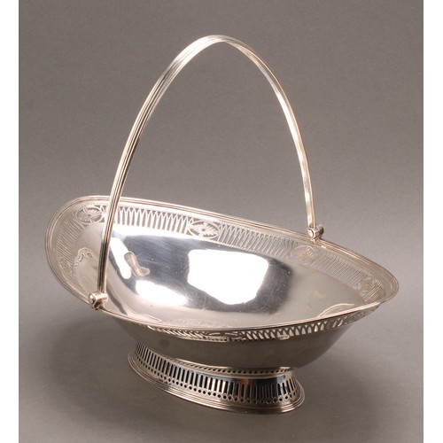 780 - A George III silver navette shaped swing-handled cake basket, pierced and engraved in the Neo-Classi... 