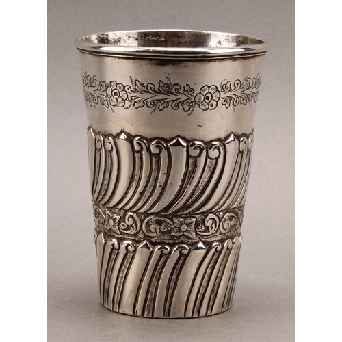 727 - A Colonial silver coloured metal tapered cylindrical beaker, probably South American, chased with ba... 