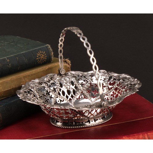1020 - An early George III silver oval swing handled sweetmeat basket, pierced and chased with flowers, sti... 