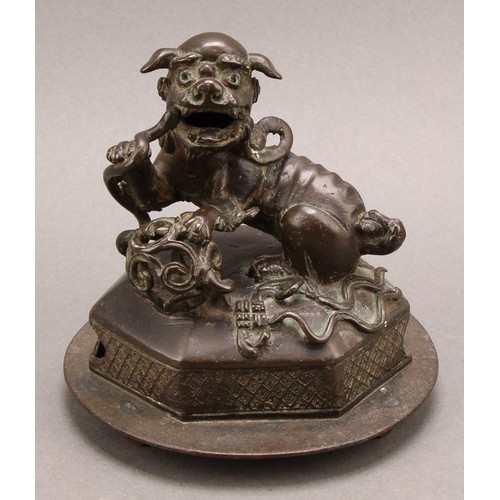 1278 - A Chinese bronze, of a foo dog and snake, hexagonal base, 14cm high overall, c. 1900