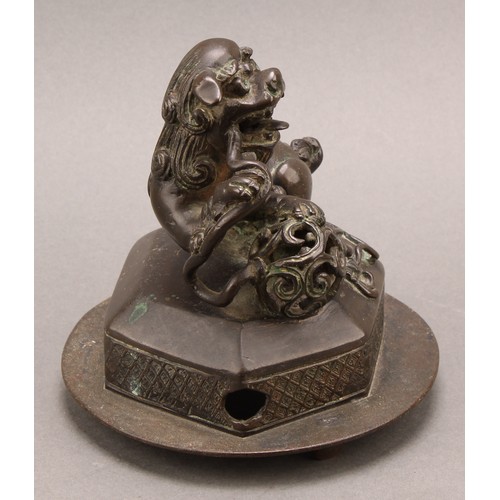 1278 - A Chinese bronze, of a foo dog and snake, hexagonal base, 14cm high overall, c. 1900