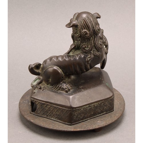 1278 - A Chinese bronze, of a foo dog and snake, hexagonal base, 14cm high overall, c. 1900