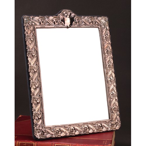 841 - A large Elizabeth II silver rectangular easel dressing table mirror, profusely embossed with flowers... 