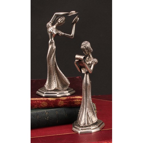 855 - A pair of Continental silver figures, of young ladies reading, and playing cymbals, 13.5cm high, imp... 