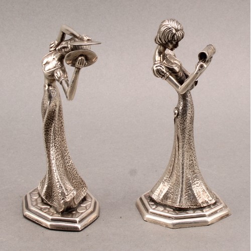 855 - A pair of Continental silver figures, of young ladies reading, and playing cymbals, 13.5cm high, imp... 