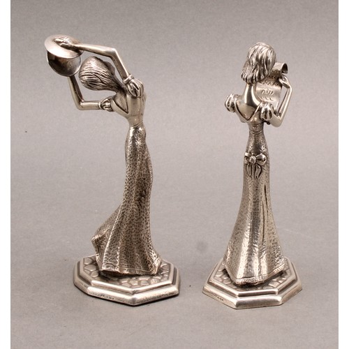 855 - A pair of Continental silver figures, of young ladies reading, and playing cymbals, 13.5cm high, imp... 