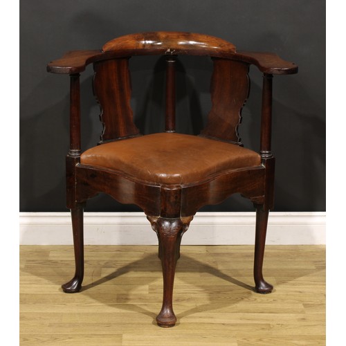 2414 - An 18th century mahogany corner elbow chair, possibly American, broad shaped arms, vasular splats, d... 