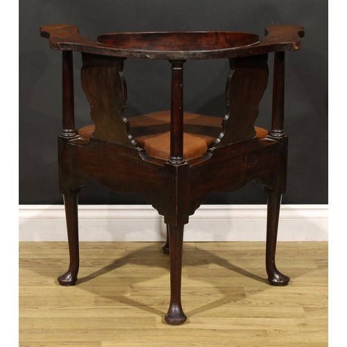 2414 - An 18th century mahogany corner elbow chair, possibly American, broad shaped arms, vasular splats, d... 