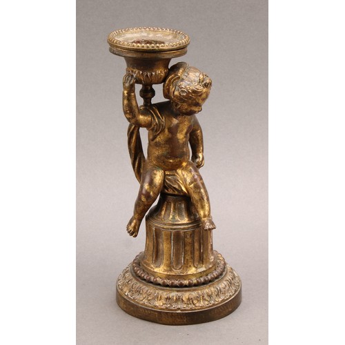 2208 - A 19th century gilt bronze figural candlestick, cast as a scantily clad putti, seated on a fluted co... 