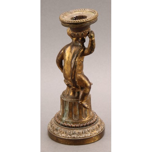 2208 - A 19th century gilt bronze figural candlestick, cast as a scantily clad putti, seated on a fluted co... 