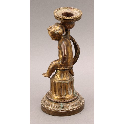 2208 - A 19th century gilt bronze figural candlestick, cast as a scantily clad putti, seated on a fluted co... 