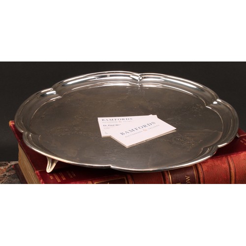 823 - A George V silver shaped circular salver, engraved with ribbon tied garlands, interlaced monograms a... 