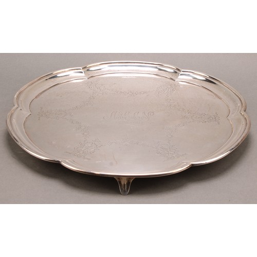 823 - A George V silver shaped circular salver, engraved with ribbon tied garlands, interlaced monograms a... 