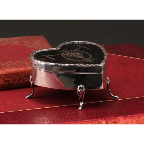 1032 - An Edwardian silver love heart shaped jewellery box, the hinged tortoise shell cover inlaid with a g... 