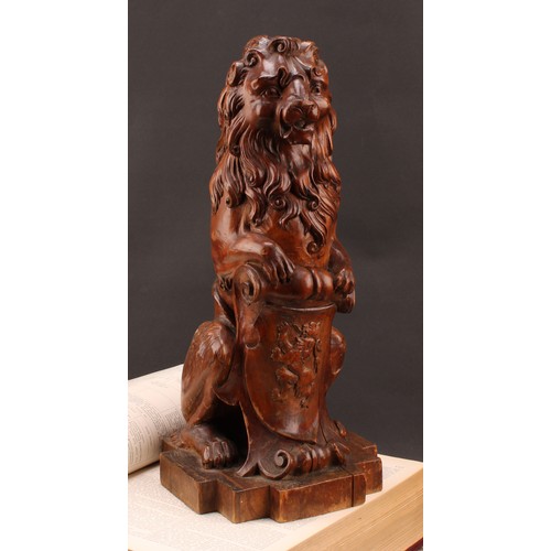 2347 - An early 20th century Scottish walnut finial, carved as a lion sejant erect leaning on the Royal Ban... 