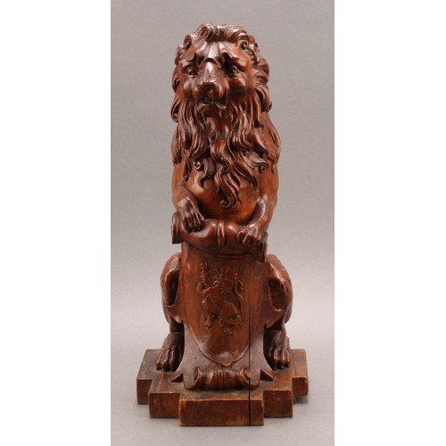 2347 - An early 20th century Scottish walnut finial, carved as a lion sejant erect leaning on the Royal Ban... 