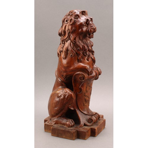 2347 - An early 20th century Scottish walnut finial, carved as a lion sejant erect leaning on the Royal Ban... 