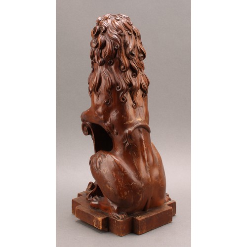 2347 - An early 20th century Scottish walnut finial, carved as a lion sejant erect leaning on the Royal Ban... 