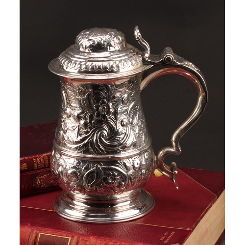 1018 - An early George III silver baluster tankard, hinged domed cover, double-scroll handle, skirted base,... 