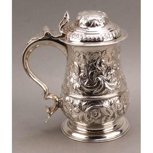 1018 - An early George III silver baluster tankard, hinged domed cover, double-scroll handle, skirted base,... 