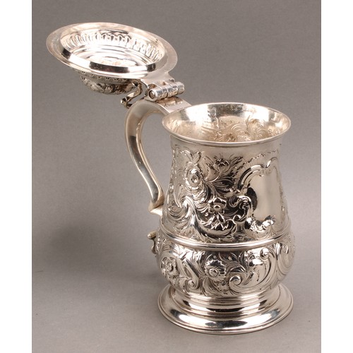 1018 - An early George III silver baluster tankard, hinged domed cover, double-scroll handle, skirted base,... 