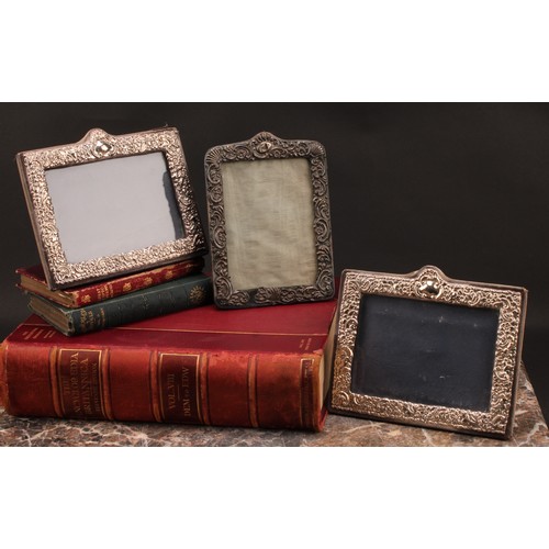 896 - A pair of Victorian style silver rectangular easel photograph frames, embossed with flowers and scro... 