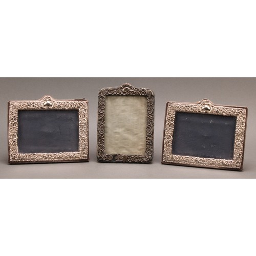 896 - A pair of Victorian style silver rectangular easel photograph frames, embossed with flowers and scro... 