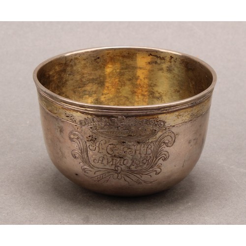 707 - A 17th century parcel-gilt silver tumbler cup, possibly Scandinavian, engraved with a crown cartouch... 