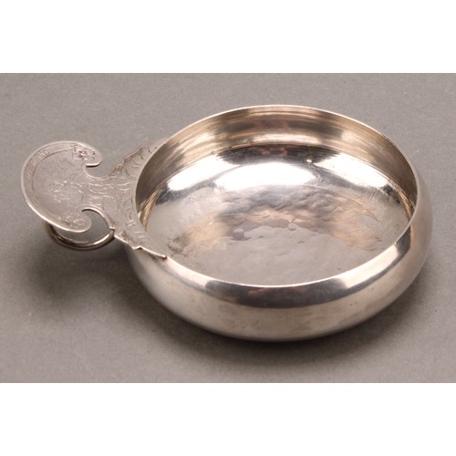 989 - An 18th/early 19th century Dutch silver porringer or wine taster, shaped lug and ring handle engrave... 