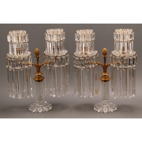 2479 - A pair of Regency gilt brass and cut glass two light table lustre candelabra, each branch fitted wit... 