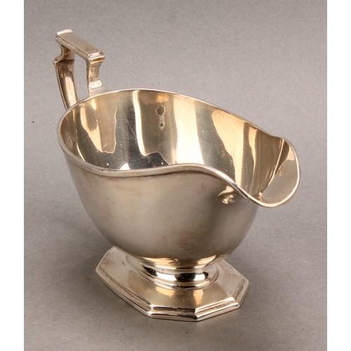 817 - A George V silver pedestal sauce boat, angular scroll handle, octagonal base, Mappin & Webb, Sheffie... 