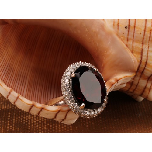 1169 - 18ct white gold Almandine/Pyrope Garnet and Diamond ring
The ring is set with an oval brilliant cut ... 